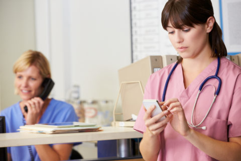 A nurse uses healthcare automation to speed up a process on her phone.