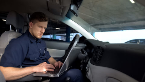 A police officer using a laptop for police internal communications